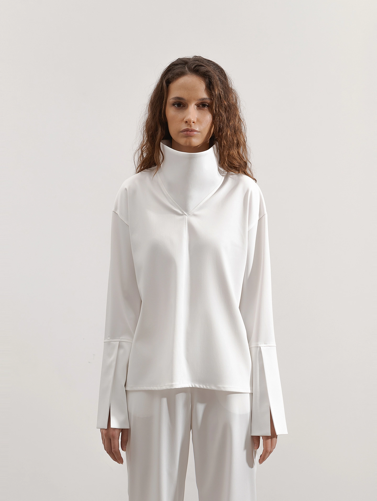 Блуза с высоким воротником-стойка и брюки с разрезами по бокам